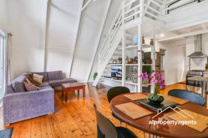 a living room with a couch and a table at The A-Frame in Halls Gap +15 photos