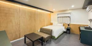 a small bedroom with a bed and a table at Hotel Barley Field Seoknam in Incheon