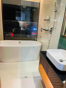 a white bathroom with a tub and a sink at Apec Mandala Tuy Hòa Phú Yên Tina House in Ðông Tác (1) +27 photos