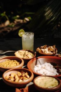 a table topped with bowls of food and a drink at DreamTime in Hikkaduwa