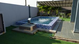 a swimming pool with blue tiles in a backyard at Deeja Homestay Kuantan in Kuantan