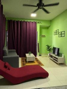 a living room with a red couch and a tv at Deeja Homestay Kuantan in Kuantan