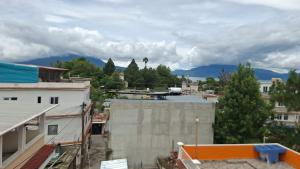 a view of a city with mountains in the background at Hostel New Brothers in Panajachel