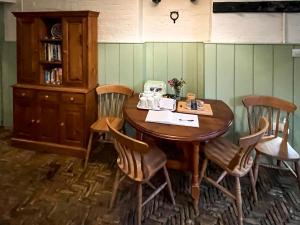 a wooden table in a room with chairs and a cabinet at Saddle Room - Uk51017 in Louth +9 photos