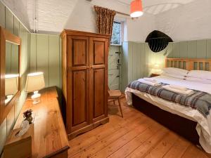 a bedroom with a large bed and a wooden cabinet at Saddle Room - Uk51017 in Louth