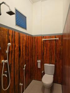 a bathroom with a toilet and a shower at Cozy Sand Beach Hotel in Arugam Bay +102 photos