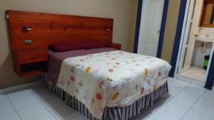 a bedroom with a bed with a wooden headboard at Hostel New Brothers in Panajachel