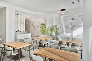 a restaurant with wooden tables and chairs at Muze Hotel in Ksamil