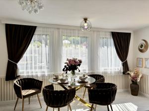 a dining room with a glass table and chairs at Gyémánt Vendégház in Doba