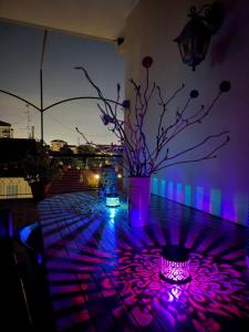 a table with a vase with purple lights on it at B&BMagicHouse in Novara