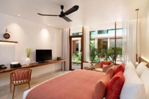 ein Schlafzimmer mit einem Bett, einer Couch und einem Fernseher in der Unterkunft FCC Angkor by Avani in Siem Reap