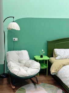 a room with a chair and a bed and a table at Phố Homestay Phan Thiết in Phan Thiet
