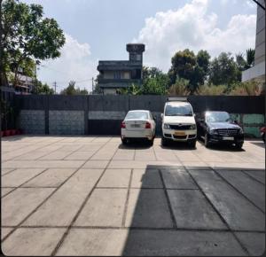 a group of three cars parked in a parking lot at Hotel PAMS in Mayiladuthurai