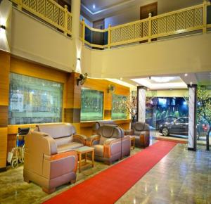 a lobby with couches and chairs in a building at Hotel PAMS in Mayiladuthurai