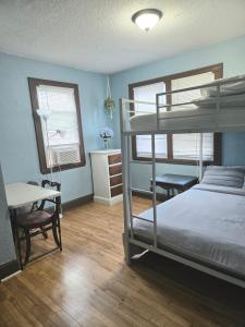 a bedroom with a bunk bed and a desk and two windows at Ana Maria del Azul in Minneapolis