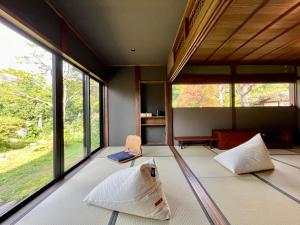 ein Zimmer mit zwei Betten und großen Fenstern in der Unterkunft Room 48 in Takayama