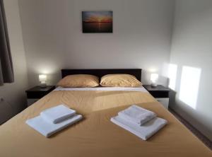 a bedroom with a bed with two towels on it at Apartment Serenity in Rogotin