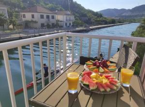 a plate of fruit and juice on a table on a balcony at Apartment Serenity in Rogotin
