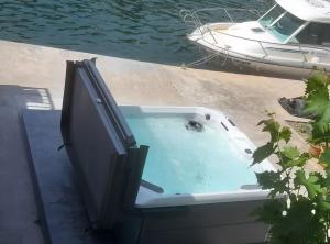a bath tub sitting on a dock next to a boat at Apartment Serenity in Rogotin +1 photo
