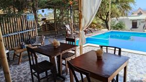 a patio with tables and chairs next to a swimming pool at Loft5 matrimonial Playa Pocitas in Máncora