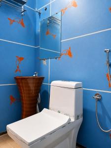 a bathroom with a toilet and a blue wall at Fargade Elite Club in Sangamner