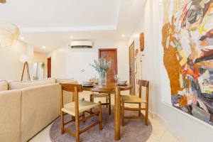 a living room with a table and a couch at Naia Residence - 2BR Oceanview in Dar es Salaam