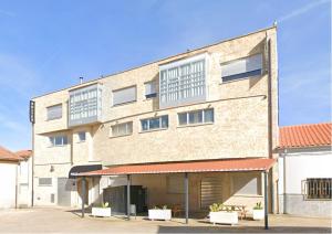 a large brick building with two balconies on it at Hostal-SPA Mare Nostrum in La Fuente de San Esteban