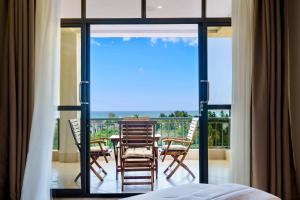 a room with a balcony with a table and chairs at Naia Residence - 2BR Oceanview in Dar es Salaam