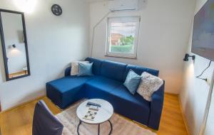 a blue couch in a living room with a table at DalEro Sunset Apartments Medjugorje in Međugorje
