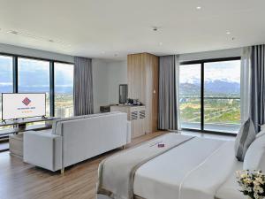 a bedroom with a large white bed and a television at Long Thuan Hotel & Resort in Phan Rang–Tháp Chàm