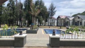 a house with a swimming pool in front of a house at The Kaluna Resort in Lamno
