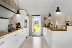 a large kitchen with white cabinets and a doorway at FY134-Middelfart-Antaresvej-4 in Middelfart