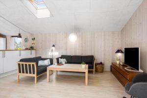 a living room with a couch and a table and a tv at FY134-Middelfart-Antaresvej-4 in Middelfart