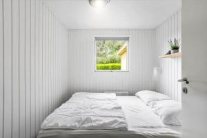 a white bedroom with a bed and a window at FY134-Middelfart-Antaresvej-4 in Middelfart
