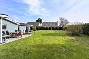 a yard with chairs and a table and a house at FY134-Middelfart-Antaresvej-4 in Middelfart