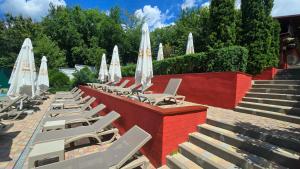 Eine Reihe von Liegestühlen mit Sonnenschirmen und eine Treppe in der Unterkunft Grace Villa in Codru