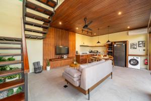 a living room with a couch and a kitchen at Nala Villa - Peaceful Hideaway with Pool & Yoga Space in Canggu