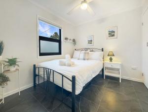 a bedroom with a bed and a window at The Nook - Lake Illawarra in Lake Illawarra