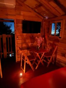 a room with a table and a television in a cabin at Mi Refugio Mamre in Tlazala de Fabela
