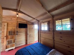 a bedroom with a bed in a room with wooden walls at Mi Refugio Mamre in Tlazala de Fabela