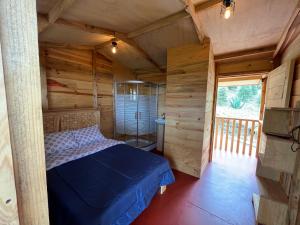a bedroom with a bed in a wooden cabin at Mi Refugio Mamre in Tlazala de Fabela