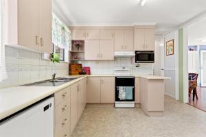 a kitchen with white cabinets and a sink at Blue Meadow - Pet Friendly in Evans Head +7 photos