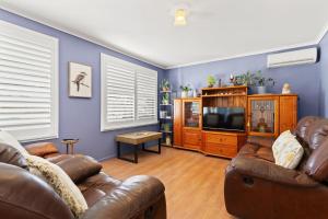 a living room with two couches and a tv at Blue Meadow - Pet Friendly in Evans Head