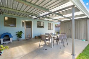 a patio with a table and chairs and a fireplace at Blue Meadow - Pet Friendly in Evans Head