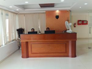 two people sitting at a reception desk in a room at Tyche Stays in Trivandrum