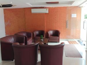 a waiting room with leather chairs and a table at Tyche Stays in Trivandrum