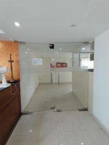 a room with a glass door with a cross on the wall at Tyche Stays in Trivandrum