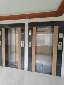 a row of metal elevators in a building at Tyche Stays in Trivandrum