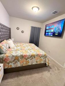 a bedroom with a bed and a flat screen tv at Cozy Retreat in San Antonio