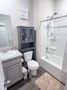 a bathroom with a toilet and a sink and a shower at Cozy Retreat in San Antonio +19 photos